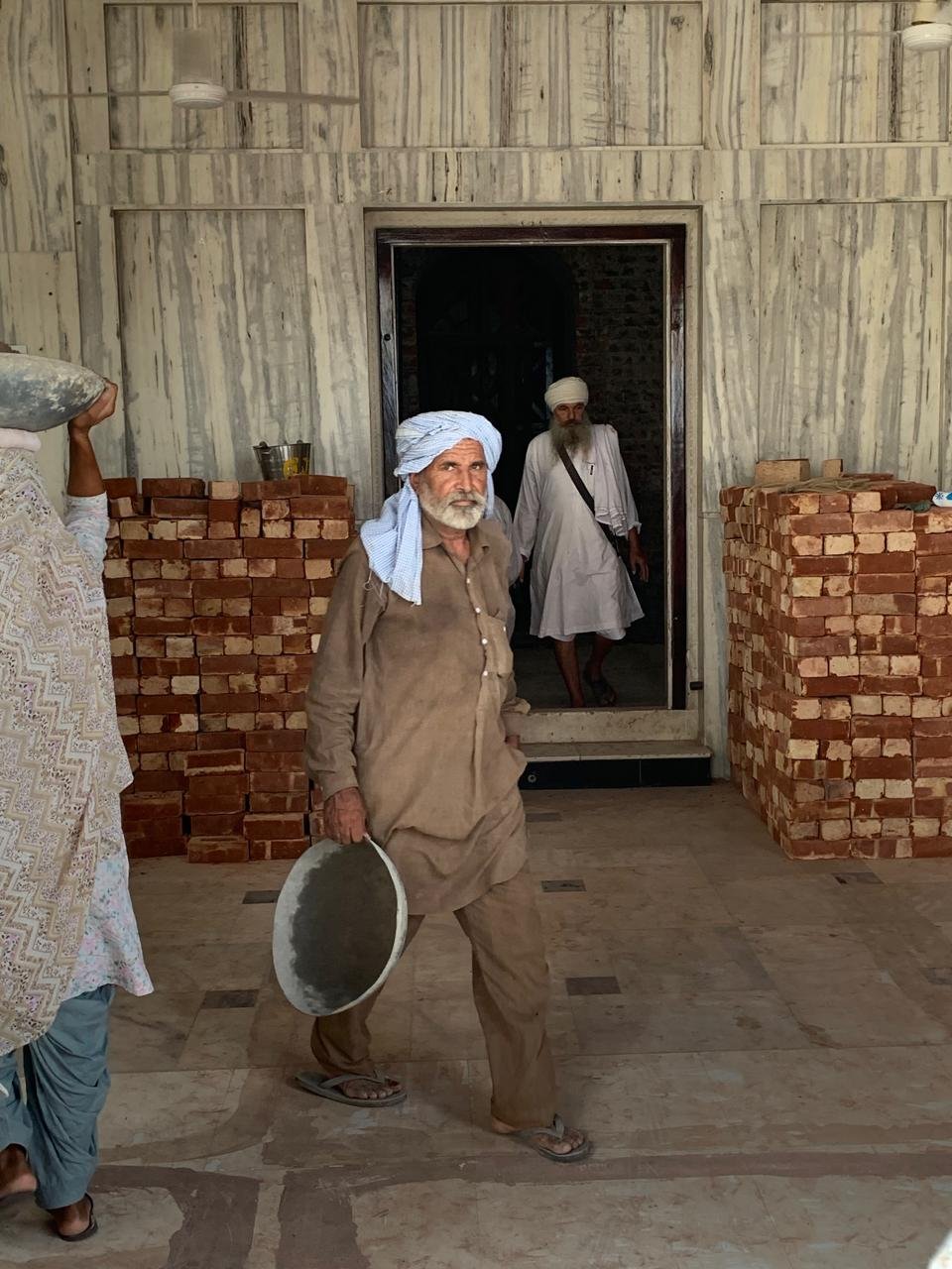 Sevadars carrying material for restoration work
